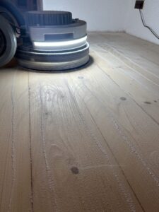 Holzboden wird mit Maschine geschliffen